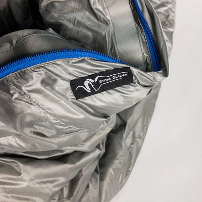 A close-up view of the product labeling found on the Stone Glacier 15 Degree Chilkoot Sleeping Bag in granite grey.