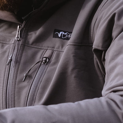 A close-up view of the product labeling found on the Stone Glacier De Havilland Jacket in granite grey.