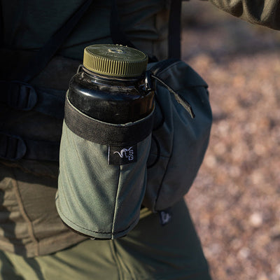 A close-up image of the Stone Glacier Hydro Holster with a Nalgene bottle positioned within, as seen being worn by a backpacker.