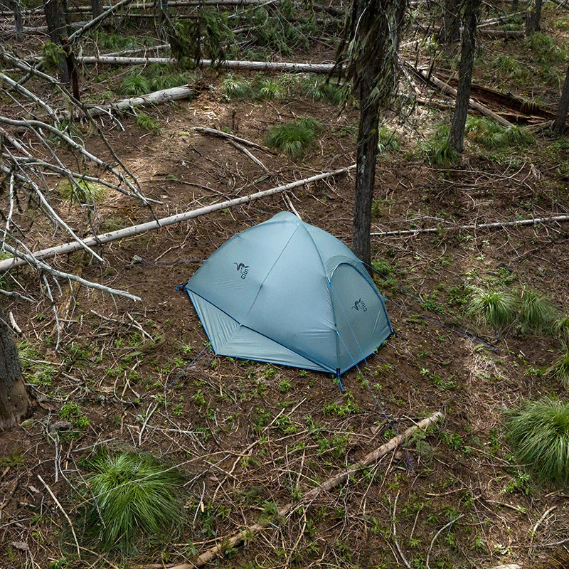 A top-down view of the Stone Glacier Sky Solus 1P Tent that is setup within a high alpine tree grove in broad daylight.